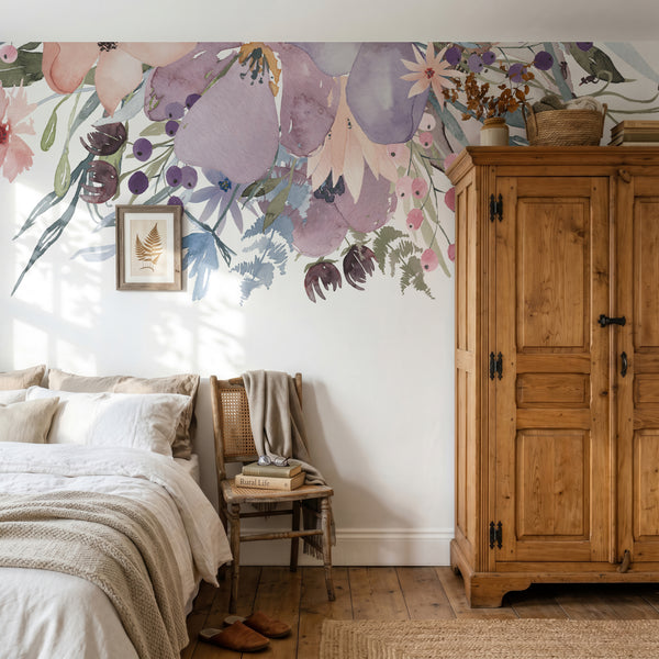 Pink and lavender floral border above a bed beside a wooden wardrobe