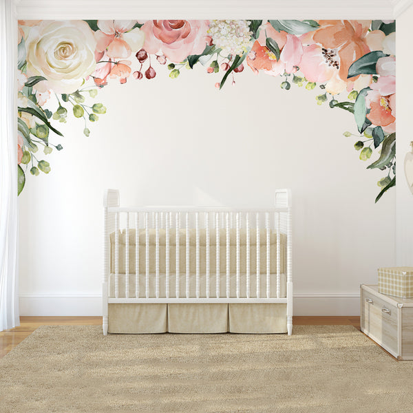 Charlotte watercolor rose and peony canopy decal arching over a white crib in a nursery