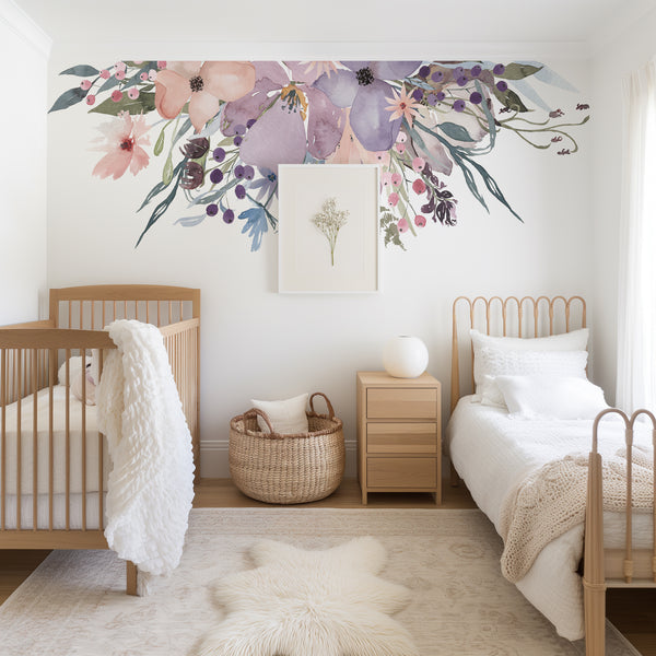 Pink and lavender flower decals arranged above a crib in a neutral nursery