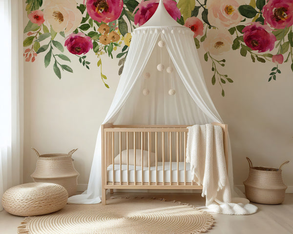 Pink floral border and trailing leaves framing a white crib canopy