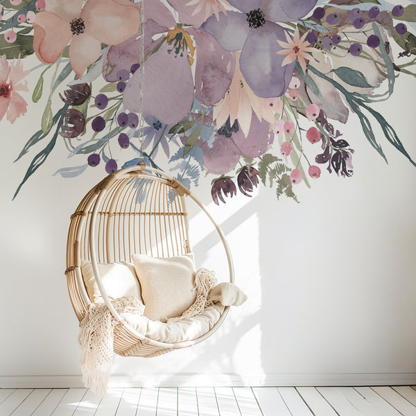 Watercolor flowers above a hanging rattan chair in a bright nursery