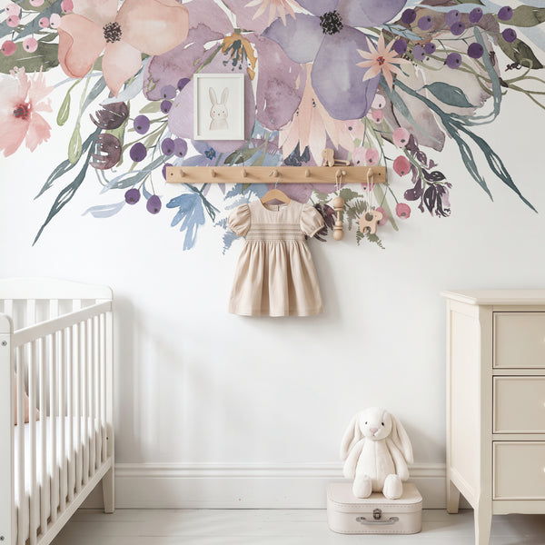Pink and lavender floral wall decal above a crib with a decorative wall hanging