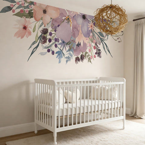 Pink and lavender watercolor floral border above a white nursery crib with a woven pendant light
