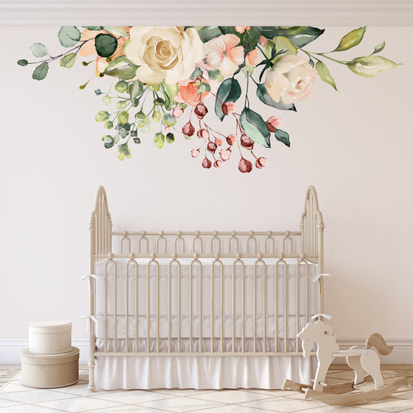 GAIA ivory and pink floral wall decal with trailing greenery above a white nursery crib