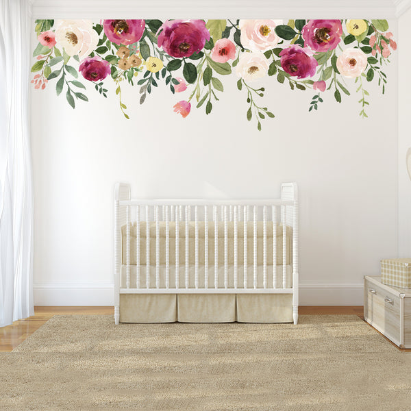 Pink and ivory floral wall border displayed above a white crib